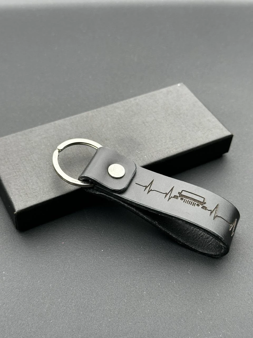The texture and engraved detail of a leather keyring